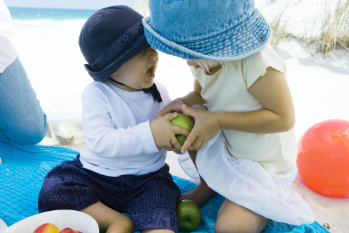 Crianças disputando maçã