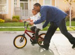 Pai ensinando filho a andar bicicleta